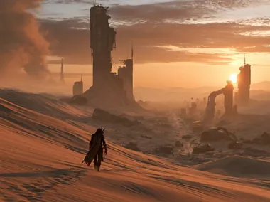 A traveller crossing desert ruins at sunset